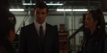Movie still from “A Hollywood Christmas” (2022), directed by Alex Ranarivelo – A man wearing a suit and tie in a warehouse; Close Up shot, Over the shoulder angle