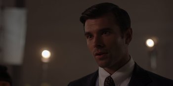 Movie still from “A Hollywood Christmas” (2022), directed by Alex Ranarivelo – A person wearing a suit and tie; Close Up shot, Over the shoulder angle