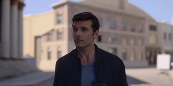 Movie still from “A Hollywood Christmas” (2022), directed by Alex Ranarivelo – A man standing in front of a brick building; Close Up shot, Over the shoulder angle