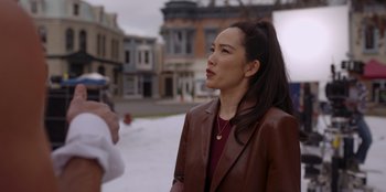 Movie still from “A Hollywood Christmas” (2022), directed by Alex Ranarivelo – A woman in a brown jacket talking to a man in a brown jacket; Medium shot, Over the shoulder angle
