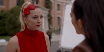 Movie still from “A Hollywood Christmas” (2022), directed by Alex Ranarivelo – A woman in a red dress talking to another woman in front of a building; Close Up shot, Over the shoulder angle