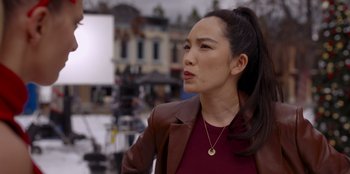 Movie still from “A Hollywood Christmas” (2022), directed by Alex Ranarivelo – A woman in a brown leather jacket looking to her left; Medium shot, Over the shoulder angle
