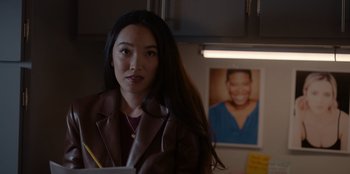 Movie still from “A Hollywood Christmas” (2022), directed by Alex Ranarivelo – A woman with long black hair is standing in front of a picture; Close Up shot, Over the shoulder angle