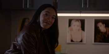 Movie still from “A Hollywood Christmas” (2022), directed by Alex Ranarivelo – A woman in a brown jacket standing in front of a picture; Close Up shot, Over the shoulder angle