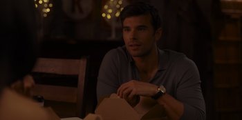 Movie still from “A Hollywood Christmas” (2022), directed by Alex Ranarivelo – A man sitting at a table with a box in front of him; Close Up shot, Over the shoulder angle