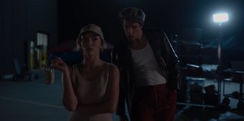 Movie still from “A Hollywood Christmas” (2022), directed by Alex Ranarivelo – A man and a woman standing next to each other in the dark; Medium shot, Low angle