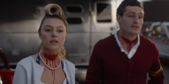 Movie still from “A Hollywood Christmas” (2022), directed by Alex Ranarivelo – A woman with blood dripping down her neck and a man with blood dripping down her neck; Close Up shot, Low angle
