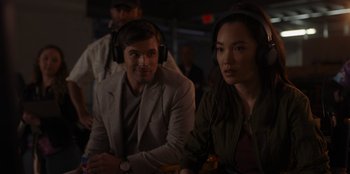 Movie still from “A Hollywood Christmas” (2022), directed by Alex Ranarivelo – A man and a woman wearing headphones in a room; Close Up shot, Over the shoulder angle