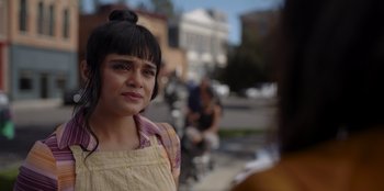 Movie still from “A Hollywood Christmas” (2022), directed by Alex Ranarivelo – A woman in a plaid shirt is standing on the sidewalk; Close Up shot, Over the shoulder angle