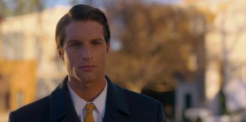 Movie still from “A Hollywood Christmas” (2022), directed by Alex Ranarivelo – A person wearing a suit and tie; Close Up shot, Low angle