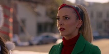Movie still from “A Hollywood Christmas” (2022), directed by Alex Ranarivelo – A woman wearing a green jacket and a red headband; Close Up shot, Over the shoulder angle