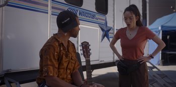 Movie still from “A Hollywood Christmas” (2022), directed by Alex Ranarivelo – A man and a woman standing in front of an rv; Medium shot, Over the shoulder angle