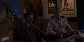 Movie still from “A Hollywood Christmas” (2022), directed by Alex Ranarivelo – A couple of men sitting next to each other at a table; Medium shot, Over the shoulder angle