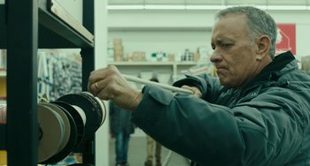 Movie still from “A Man Called Otto” (2022), directed by Marc Forster – An older man is tying a cord to a spool of yarn; Close Up shot, Low angle