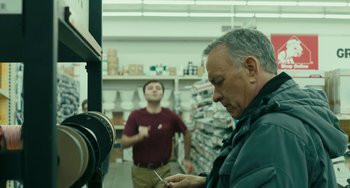 Movie still from “A Man Called Otto” (2022), directed by Marc Forster – A man looking at something in a store; Medium shot, Over the shoulder angle