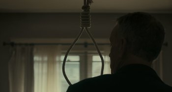 Movie still from “A Man Called Otto” (2022), directed by Marc Forster – A man with a noose around his neck looking out a window; Close Up shot, Low angle
