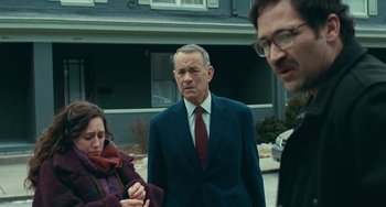 Movie still from “A Man Called Otto” (2022), directed by Marc Forster – A man in a suit standing next to two other people; Medium shot, Low angle