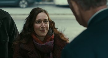 Movie still from “A Man Called Otto” (2022), directed by Marc Forster – A woman wearing a scarf and a red jacket talking to a man; Close Up shot, Over the shoulder angle