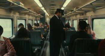 Movie still from “A Man Called Otto” (2022), directed by Marc Forster – A man in a black suit and a black hat standing on a train; Wide shot, High angle