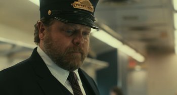 Movie still from “A Man Called Otto” (2022), directed by Marc Forster – A man in a suit and hat on a train; Close Up shot, Over the shoulder angle
