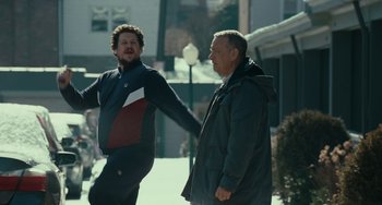 Movie still from “A Man Called Otto” (2022), directed by Marc Forster – Two men are talking and laughing together outside; Medium shot, Low angle