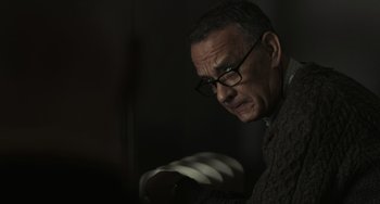 Movie still from “A Man Called Otto” (2022), directed by Marc Forster – An older man wearing glasses and a sweater looking down; Close Up shot, Over the shoulder angle