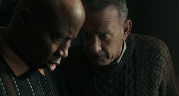 Movie still from “A Man Called Otto” (2022), directed by Marc Forster – Two men are looking at each other in a dark room; Close Up shot, Over the shoulder angle