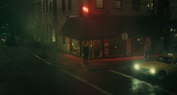 Movie still from “A Man Called Otto” (2022), directed by Marc Forster – A man standing on the side of the street at night; Extreme Wide shot, High angle