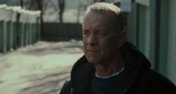 Movie still from “A Man Called Otto” (2022), directed by Marc Forster – An older man with a grumpy look on his face; Close Up shot, Over the shoulder angle