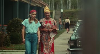 Movie still from “A Man Called Otto” (2022), directed by Marc Forster – Two women walking down the sidewalk of a street; Wide shot, Over the shoulder angle