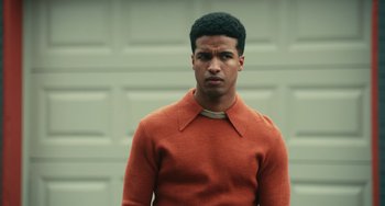 Movie still from “A Man Called Otto” (2022), directed by Marc Forster – A man in an orange sweater standing in front of a garage door; Medium shot, Low angle