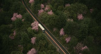 Movie still from “A Man Called Otto” (2022), directed by Marc Forster – An aerial view of a bus traveling down the road; Extreme Wide shot, High angle