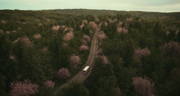 Movie still from “A Man Called Otto” (2022), directed by Marc Forster – An aerial view of a bus driving down the road; Extreme Wide shot, High angle