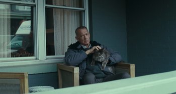 Movie still from “A Man Called Otto” (2022), directed by Marc Forster – A man sitting in a chair petting a cat; Medium shot, Low angle