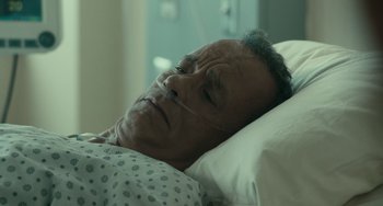 Movie still from “A Man Called Otto” (2022), directed by Marc Forster – An older man laying in a hospital bed with his eyes closed; Close Up shot, High angle