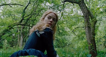 Movie still from “The Favourite” (2018), directed by Yorgos Lanthimos – A woman with long blonde hair is in the woods; Medium shot, Low angle