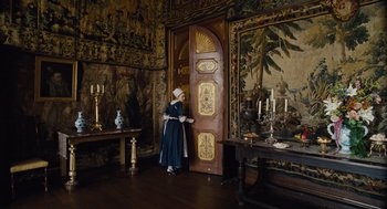 Movie still from “The Favourite” (2018), directed by Yorgos Lanthimos – A woman dressed in period clothing standing in front of an ornate door; Wide shot, High angle