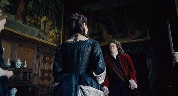 Movie still from “The Favourite” (2018), directed by Yorgos Lanthimos – Two people dressed in period clothing stand in front of a painting; Medium shot, Over the shoulder angle