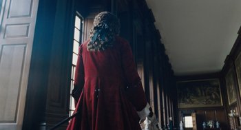 Movie still from “The Favourite” (2018), directed by Yorgos Lanthimos – A woman in a red coat holding a pair of walking sticks; Medium shot, Low angle