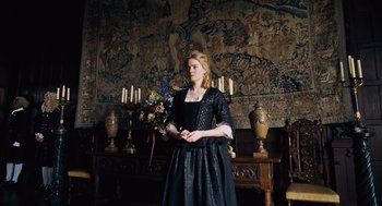 Movie still from “The Favourite” (2018), directed by Yorgos Lanthimos – A woman dressed in medieval garb standing in front of a wall; Medium shot, Low angle