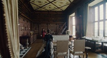 Movie still from “The Favourite” (2018), directed by Yorgos Lanthimos – Two people in a room with many books on the walls; Extreme Wide shot, High angle