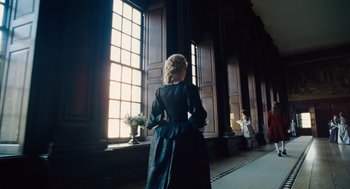 Movie still from “The Favourite” (2018), directed by Yorgos Lanthimos – A woman standing in front of a large window; Wide shot, Low angle