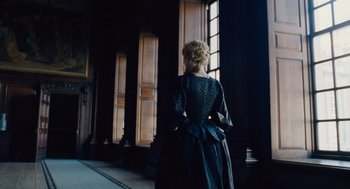 Movie still from “The Favourite” (2018), directed by Yorgos Lanthimos – A woman standing in front of a large window; Medium shot, Low angle