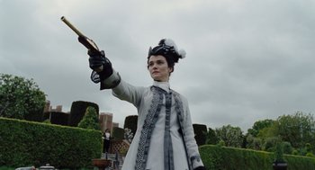 Movie still from “The Favourite” (2018), directed by Yorgos Lanthimos – A woman dressed in a costume holding a cane; Medium shot, Low angle