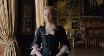 Movie still from “The Favourite” (2018), directed by Yorgos Lanthimos – A woman in a black and white dress standing in a room; Medium shot, Low angle