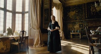 Movie still from “The Favourite” (2018), directed by Yorgos Lanthimos – A woman dressed in period clothing standing in front of a window; Wide shot, Low angle
