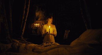 Movie still from “The Favourite” (2018), directed by Yorgos Lanthimos – A woman holding a lit candle in a dark room; Medium shot, High angle