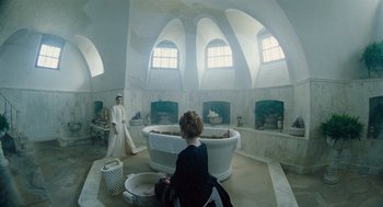 Movie still from “The Favourite” (2018), directed by Yorgos Lanthimos – A woman in a bath room with a man in a bath room with a tub; Wide shot, High angle