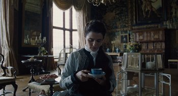 Movie still from “The Favourite” (2018), directed by Yorgos Lanthimos – A woman holding a tea cup in her hands; Medium shot, Low angle