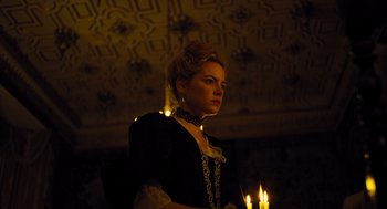 Movie still from “The Favourite” (2018), directed by Yorgos Lanthimos – A woman standing in front of candles in a dark room; Medium shot, Low angle